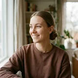 Young woman with light brown hair in a low bun wearing a cocoa lounge sweatshirt