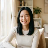 Young woman with shoulder-length black hair in a cream fitted long-sleeve top